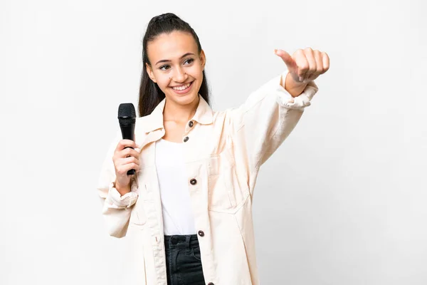 Joven Cantante Mujer Recogiendo Micrófono Sobre Aislado Fondo Blanco Dando — Foto de Stock