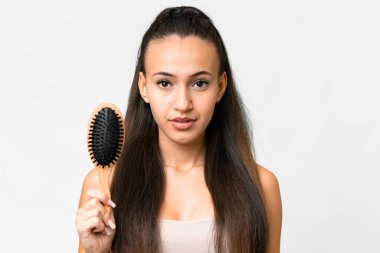 Genç Arap kadın, izole edilmiş beyaz arka planda saç tarağıyla