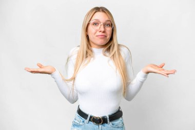 Young pretty blonde woman over isolated white background having doubts while raising hands