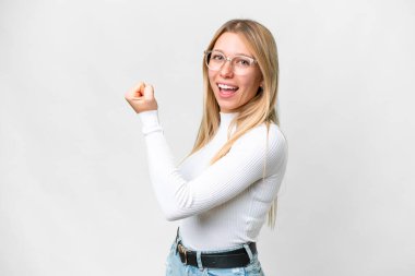 Genç, güzel sarışın kadın, izole edilmiş beyaz arka planda zaferi kutluyor.