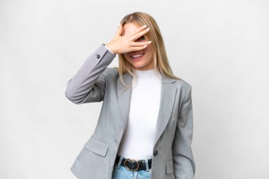 Young pretty blonde woman over isolated white background covering eyes by hands and smiling