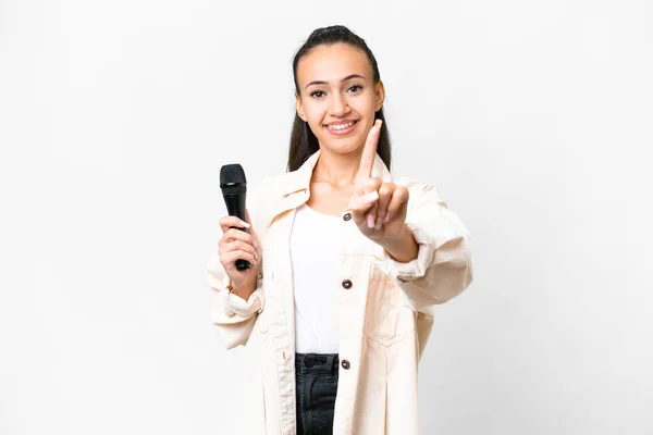 Joven Cantante Mujer Recogiendo Micrófono Sobre Aislado Fondo Blanco Mostrando — Foto de Stock