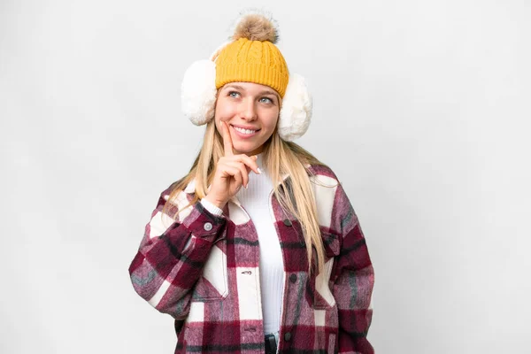 年轻漂亮的金发女人 披着冬衣 披着孤零零的白色背景 一边抬头 一边想着一个主意 — 图库照片