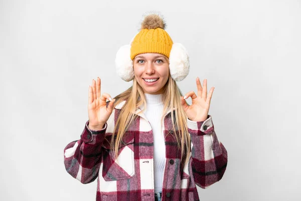 年轻漂亮的金发女人 披着冬衣 披着孤零零的白色背景 手指头上挂着一个可怜虫标志 — 图库照片