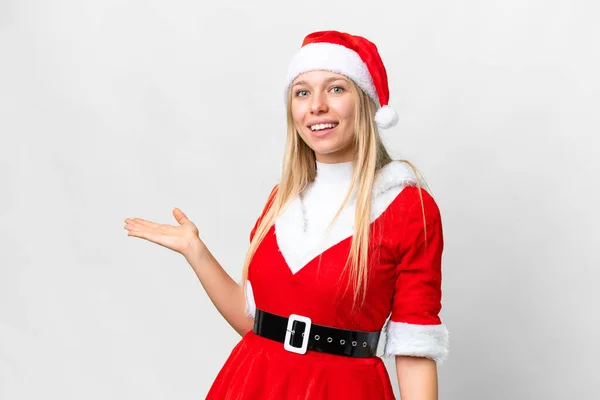 年轻的金发女郎 头戴一顶圣诞帽 头戴白色的孤立背景 向旁边伸出手来 感谢她的邀请 — 图库照片