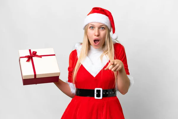 Молодая Блондинка Рождественской Шляпе Подарком Изолированном Белом Фоне Удивлена Указывает — стоковое фото