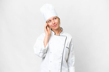 Genç aşçı kadın izole edilmiş beyaz arka plan bir fikir düşünüyor.