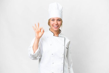 Genç aşçı kadın izole edilmiş beyaz arka planda parmaklarıyla işaret veriyor.