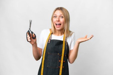 Genç sarışın terzi kadın izole edilmiş beyaz arka plan ve şok olmuş yüz ifadesi.