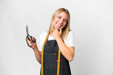 Genç sarışın terzi kadın soyutlanmış beyaz arka planda mutlu ve gülümsüyor.