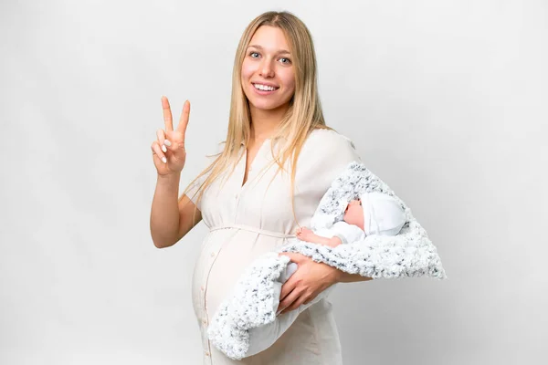 若いです可愛いです妊娠中の女性とともに彼女の新生児上の隔離された白い背景笑顔とショーの勝利サイン — ストック写真