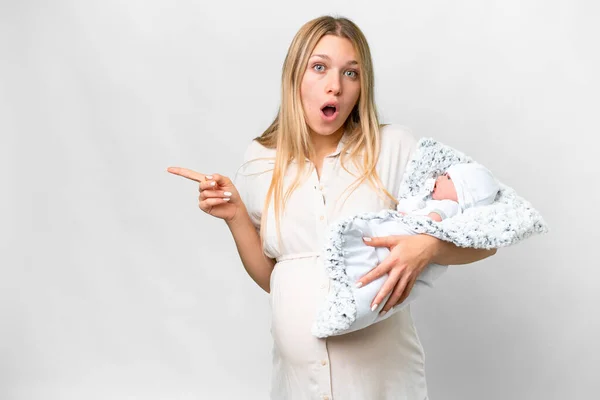 若いですかなり妊娠女性とともに彼女の新生児上の隔離された白い背景驚きと指摘側 — ストック写真