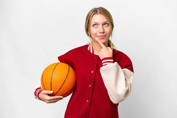 年轻的金发女子在孤立无援的背景下打篮球 一边抬起头来 一边怀疑 — 图库照片