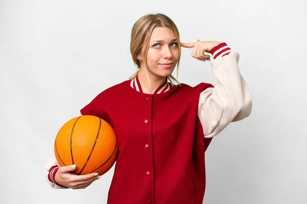 若いですブロンド女性プレイバスケットボール上の隔離された背景を持っている疑問と思考 — ストック写真