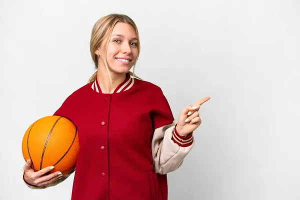 若いですブロンド女性プレイバスケットボール上の隔離された背景指差し指へザ側 — ストック写真