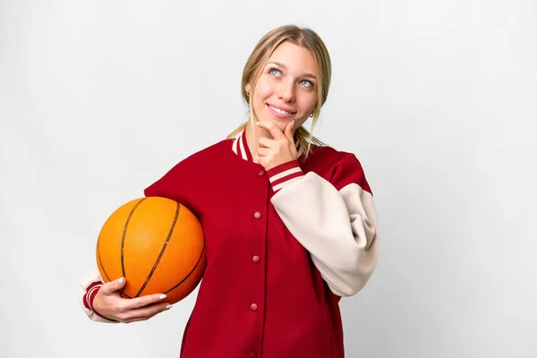 Молода Блондинка Грає Баскетбол Над Ізольованим Тлом Дивлячись Вгору Посміхаючись — стокове фото