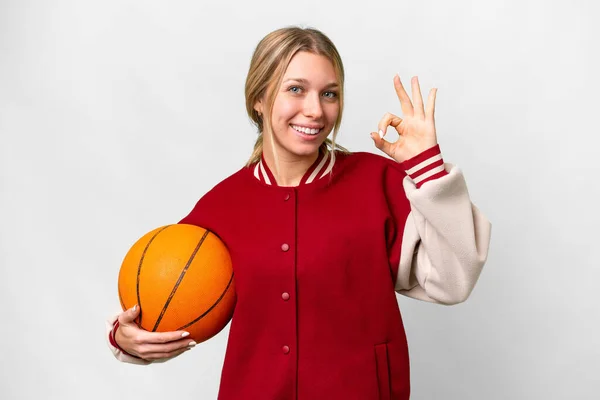 年轻的金发女子在与世隔绝的背景下打篮球 手指头显示出好的手势 — 图库照片