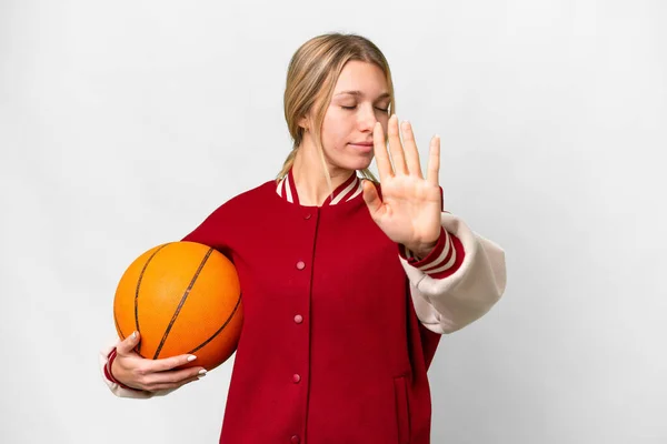 若いですブロンド女性遊びバスケットボール上の隔離された背景作りストップジェスチャーと失望 — ストック写真