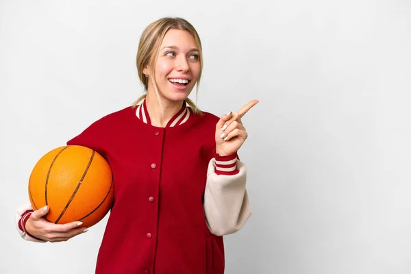 若いですブロンド女性プレイバスケットボール上の隔離された背景に実現しようとしています解決策指を持ち上げながら — ストック写真