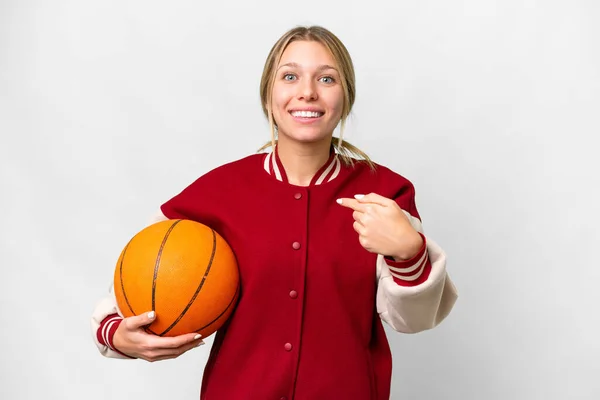 若いですブロンド女性遊びますバスケットボール上の孤立した背景とともに驚き顔式 — ストック写真