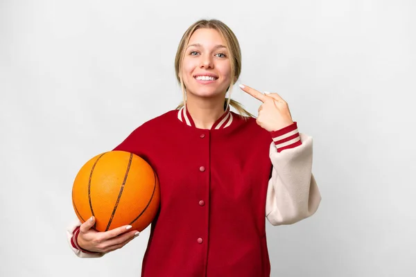 若いですブロンド女性プレイバスケットボール上の隔離された背景与えますA親指アップジェスチャー — ストック写真