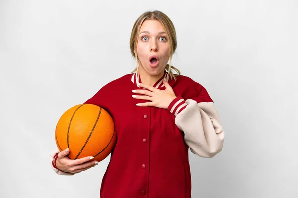 若いですブロンド女性プレイバスケットボール上の隔離された背景驚きとショックを受けながら見ます右 — ストック写真