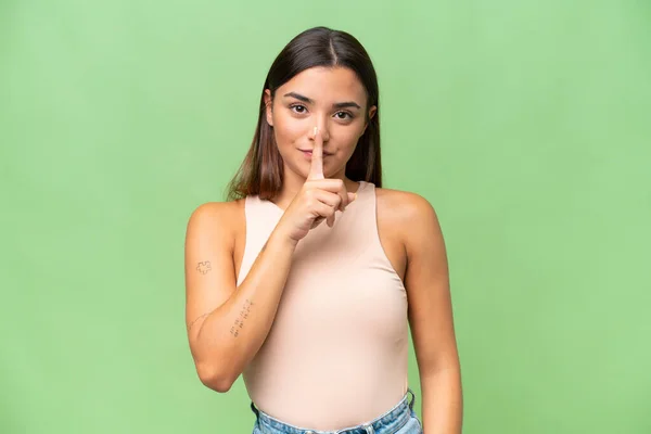 年轻的高加索女人被绿色的彩色背景隔离 表现出沉默的姿态 用手指捂住嘴 — 图库照片