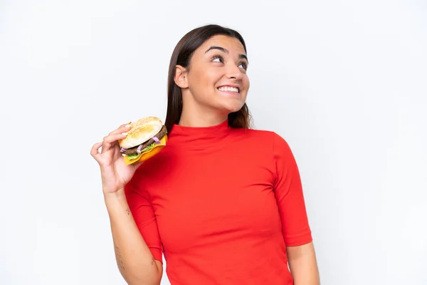 Young Caucasian Woman Holding Burger Isolated White Background Looking While — Fotografia de Stock