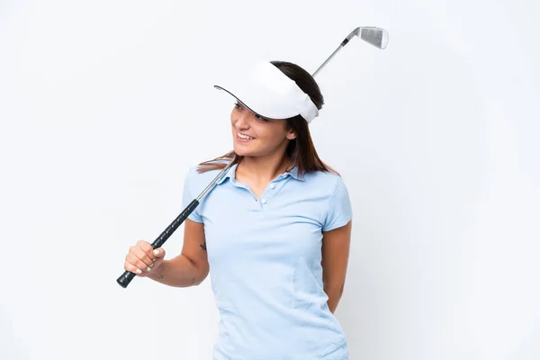 年轻的高加索女人在打高尔夫球时被白色背景隔离着 看着旁边 微笑着 — 图库照片