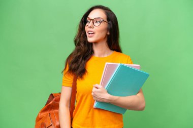 Young student caucasian woman over isolated background thinking an idea while looking up