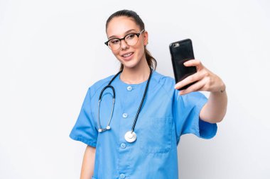 Beyaz arka planda izole edilmiş genç beyaz cerrah kadın selfie çekiyor.