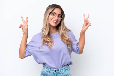 Beyaz arka planda izole edilmiş genç Uruguaylı kadın iki eliyle zafer işareti gösteriyor.