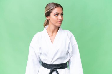 Genç Uruguaylı kadın tecrit edilmiş arka planda karate yapıyor.