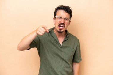 Beyazların arka planında izole edilmiş genç beyaz adam hayal kırıklığına uğramış ve ön tarafı işaret ediyor.