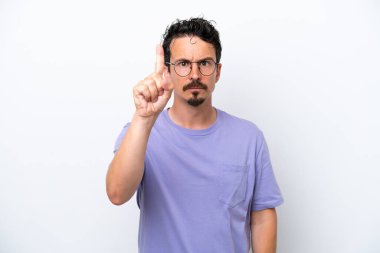 Bıyıklı genç bir adam beyaz arka planda izole edilmiş ciddi bir ifadeye sahip birini sayıyor.