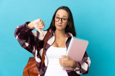 Tecrit edilmiş genç bir bayan öğrenci, olumsuz bir ifadeyle baş parmağını aşağı gösteriyor.