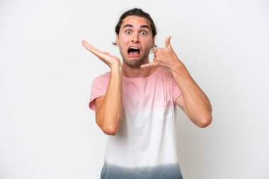 Beyaz arka planda izole edilmiş beyaz, yakışıklı bir adam telefon jesti yapıyor ve şüpheli.