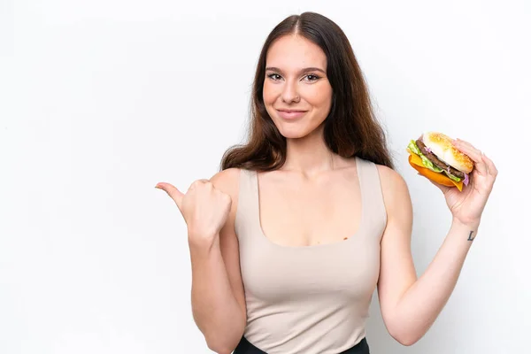 Молода Біла Жінка Тримає Бургер Ізольовано Білому Тлі Вказуючи Бік — стокове фото