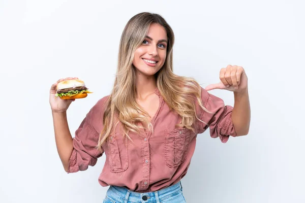 Młoda Ładna Urugwajska Kobieta Trzyma Hamburgera Odizolowany Białym Tle Dumny — Zdjęcie stockowe