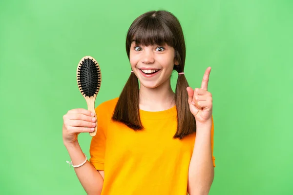 Little caucasian girl with hair comb over isolated background pointing up a great idea
