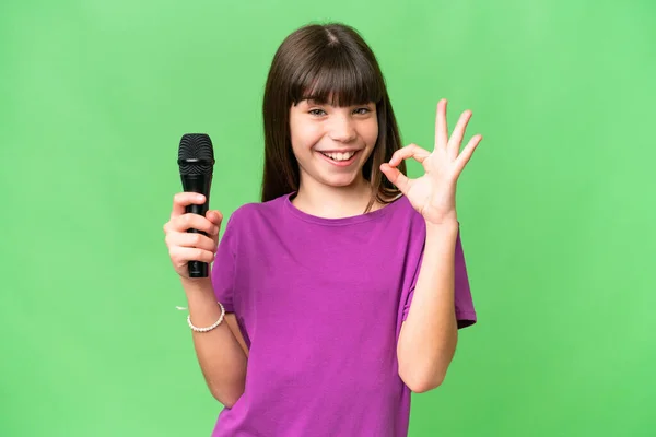 Little Singer Girl Picking Microphone Isolated Background Showing Sign Fingers — Stock Photo, Image