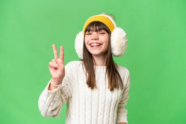 小さなCaucasian女の子身に着けています冬マフ上の隔離された背景笑顔とショー勝利サイン — ストック写真