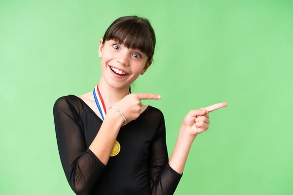 Malá Kavkazská Dívka Medailemi Nad Izolovaným Pozadím Překvapená Ukazující Stranou — Stock fotografie