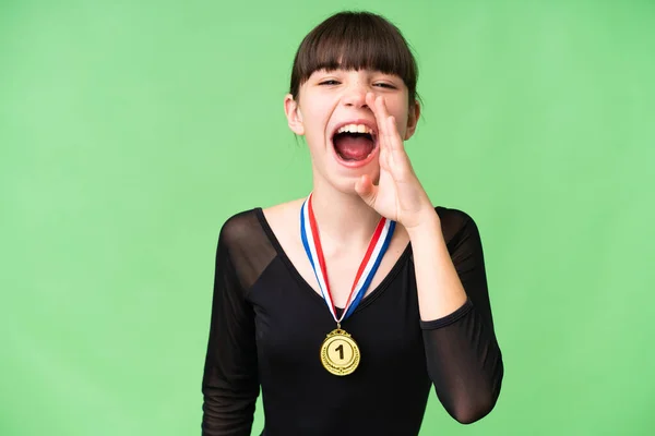 stock image Little caucasian girl with medals over isolated background shouting with mouth wide open