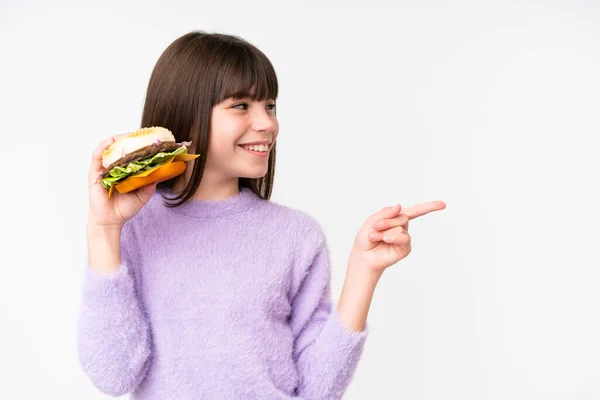 배경에서 햄버거를 코카서스 소녀는 제품을 제공하기 가리키고 — 스톡 사진