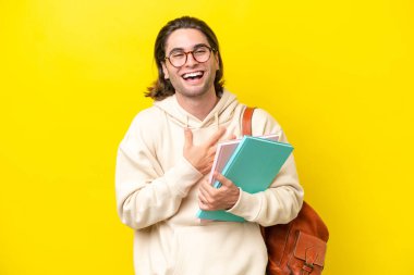 Sarı arka planda izole edilmiş yakışıklı genç bir adam. Çok gülümsüyor.