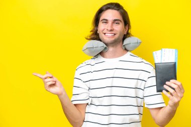 Şişirilebilir seyahat yastığı olan yakışıklı adam, parmağını yana doğru uzat.