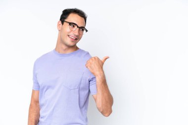 Beyaz arka planda izole edilmiş genç beyaz bir adam bir ürün sunmak için kenarı işaret ediyor.