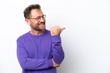 Beyaz arka planda izole edilmiş orta yaşlı beyaz bir adam bir ürün sunmak için kenarı işaret ediyor.