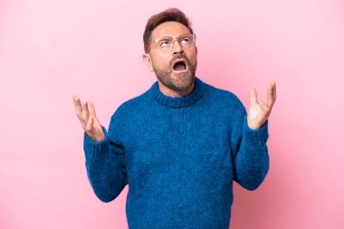 Middle age caucasian man isolated on pink background stressed overwhelmed